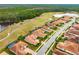 Aerial view of home with screened-in pool, tile roof, and golf course view at 2824 S Asciano Ct, New Smyrna Beach, FL 32168
