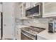 Modern kitchen with stainless steel appliances, stylish backsplash, and white cabinets at 2824 S Asciano Ct, New Smyrna Beach, FL 32168