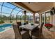 Outdoor dining on the patio overlooking the pool, lush lawn, and wooded area at 2824 S Asciano Ct, New Smyrna Beach, FL 32168