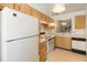 View of kitchen with white appliances and wood cabinets at 2916 Duchess Oak Ct, St Cloud, FL 34769