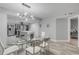 Glass dining table with white chairs, located near the kitchen at 3001 S Atlantic Ave # 501, New Smyrna Beach, FL 32169