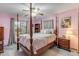 Bedroom with pink walls, four-poster bed, and ceiling fan at 3039 Tamarind Dr, Edgewater, FL 32141