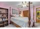 Bedroom with pink walls, four-poster bed, and ceiling fan at 3039 Tamarind Dr, Edgewater, FL 32141