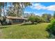 Large backyard with lush green grass and mature trees at 3112 Needle Palm Dr, Edgewater, FL 32141