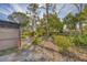 Partially fenced backyard with mature trees and shrubs at 3120 Pine Tree Dr, Edgewater, FL 32141