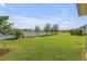 Landscaped backyard with lush lawn and lake view at 3203 Monaco Blvd, New Smyrna Beach, FL 32168