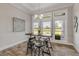 Casual dining area with a rustic table and chairs, and large windows at 3203 Monaco Blvd, New Smyrna Beach, FL 32168