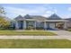 Single-story home with gray siding, a three-car garage, and a landscaped yard at 3203 Monaco Blvd, New Smyrna Beach, FL 32168