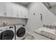 Laundry room with modern washer and dryer, upper cabinets, and granite countertop at 3203 Monaco Blvd, New Smyrna Beach, FL 32168