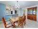 Bright dining room with wood table and chairs, open to kitchen at 325 Causeway # E 203, New Smyrna Beach, FL 32169