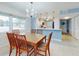 Bright dining room with wood table and chairs, open to kitchen at 325 Causeway # E 203, New Smyrna Beach, FL 32169