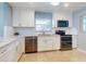 Bright kitchen with granite counters, white cabinets, and stainless steel appliances at 325 Causeway # E 203, New Smyrna Beach, FL 32169