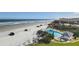 Aerial view of beach, pool, and coastal buildings at 401 N Atlantic Ave # 504, New Smyrna Beach, FL 32169