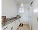 Bright laundry room with granite countertops and white cabinets at 434 Bouchelle Dr # 202, New Smyrna Beach, FL 32169