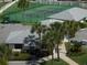 Aerial view of tennis court, clubhouse, and palm trees at 4501 S Atlantic Ave # 5180, New Smyrna Beach, FL 32169