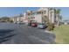 Condominium exterior featuring palm trees, red roof, balconies, and on-site parking at 456 Bouchelle Dr # 202, New Smyrna Beach, FL 32169