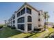 Condominium exterior showcasing screened lanais, stucco facade, and neatly manicured landscaping at 456 Bouchelle Dr # 202, New Smyrna Beach, FL 32169