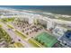 Aerial view showing condo building, parking lot, and tennis court at 5203 S Atlantic Ave # 412B, New Smyrna Beach, FL 32169