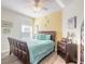 Bedroom with a king-size bed and yellow accent wall at 5300 S Atlantic Ave # 15-401, New Smyrna Beach, FL 32169