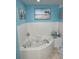 This blue bathroom includes a corner soaking tub with jets and tiled walls at 5300 S Atlantic Ave # 5-206, New Smyrna Beach, FL 32169