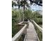 Scenic wooden boardwalk winding through a lush, natural setting with dense trees at 5300 S Atlantic Ave # 5-206, New Smyrna Beach, FL 32169