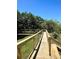 Wooden boardwalk path with railings, leading through lush greenery at 5300 S Atlantic Ave # 8-302, New Smyrna Beach, FL 32169