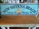 New Smyrna Beach coordinates sign on wooden table at 541 S Peninsula Ave # A03, New Smyrna Beach, FL 32169