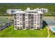 Aerial view of a beachfront building with tennis courts at 5499 S Atlantic Ave # 904, New Smyrna Beach, FL 32169