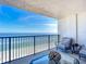 Balcony with ocean view, seating, and glass top table at 5499 S Atlantic Ave # 904, New Smyrna Beach, FL 32169