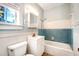 Clean bathroom with light blue tiled walls and a shower/tub combo at 608 Magnolia St, New Smyrna Beach, FL 32168