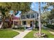 Two-story yellow house with a wraparound porch and landscaped yard at 608 Magnolia St, New Smyrna Beach, FL 32168