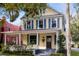 Two-story yellow house with a wraparound porch and mature trees at 608 Magnolia St, New Smyrna Beach, FL 32168