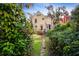 Back of charming yellow house with deck and pathway leading to the yard at 608 Magnolia St, New Smyrna Beach, FL 32168