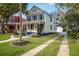 Front view of charming yellow house with driveway and landscaping at 608 Magnolia St, New Smyrna Beach, FL 32168