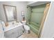 Clean bathroom with a light green tub and vanity at 81 Alberta Ave, Ponce Inlet, FL 32127