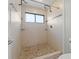 Well-lit bathroom featuring a tiled walk-in shower, built-in shower storage, and a window providing natural light at 105 Wood Duck Cir # 1C, Daytona Beach, FL 32119
