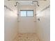 Bright bathroom showcasing a tiled shower with dual shower heads and a window for natural lighting at 105 Wood Duck Cir # 1C, Daytona Beach, FL 32119