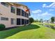 View of the back of the home with an enclosed patio and yard space along the waterfront at 105 Wood Duck Cir # 1C, Daytona Beach, FL 32119