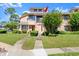 Charming two-story townhouse with manicured lawn, mature trees, and a welcoming walkway to the front door at 105 Wood Duck Cir # 1C, Daytona Beach, FL 32119