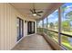 Covered and screened-in porch with ceiling fan and views of the pond and landscaping at 105 Wood Duck Cir # 1C, Daytona Beach, FL 32119