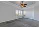 Primary bedroom with ceiling fan and grey carpet at 107 Via Amalfi, New Smyrna Beach, FL 32169