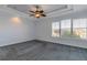 Primary bedroom with ceiling fan and grey carpet at 107 Via Amalfi, New Smyrna Beach, FL 32169