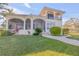 Back view of two story house with covered patio and lush landscaping at 107 Via Amalfi, New Smyrna Beach, FL 32169