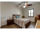 Bedroom with wood flooring, ceiling fan, and striped bedding at 108 Tuscany Villas Dr # 15, Edgewater, FL 32141