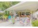 Relaxing covered patio with an outdoor seating area, plants, and views of the backyard at 115 E Turgot, Edgewater, FL 32132