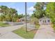 Charming home exterior with a white picket fence, lush landscaping, and a detached garage at 115 E Turgot, Edgewater, FL 32132