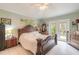 Main bedroom with wood bed frame and access to backyard at 1155 Kilkenny Ln, Ormond Beach, FL 32174