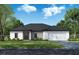 One-story home with a two-car garage, and dark gray roof at 122 Azalea Rd, Edgewater, FL 32141