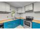 Bright kitchen features teal cabinets, butcher block countertops, and stainless steel appliances at 1732 Travelers Palm Dr, Edgewater, FL 32132