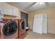 Laundry room with washer, dryer, and extra storage at 1732 Travelers Palm Dr, Edgewater, FL 32132